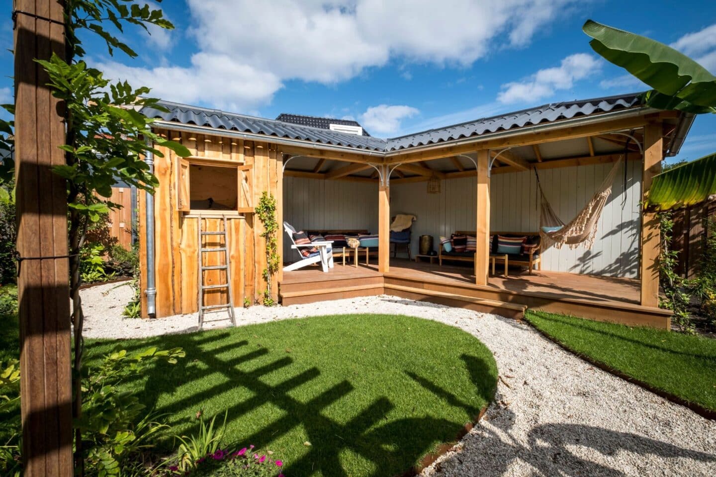 Ruime veranda met speelhuis achtertuin